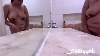 زوجة عربية ممتلئة الجسم تتباهى بثدييها الضخمين في حمام بخاري ساخن